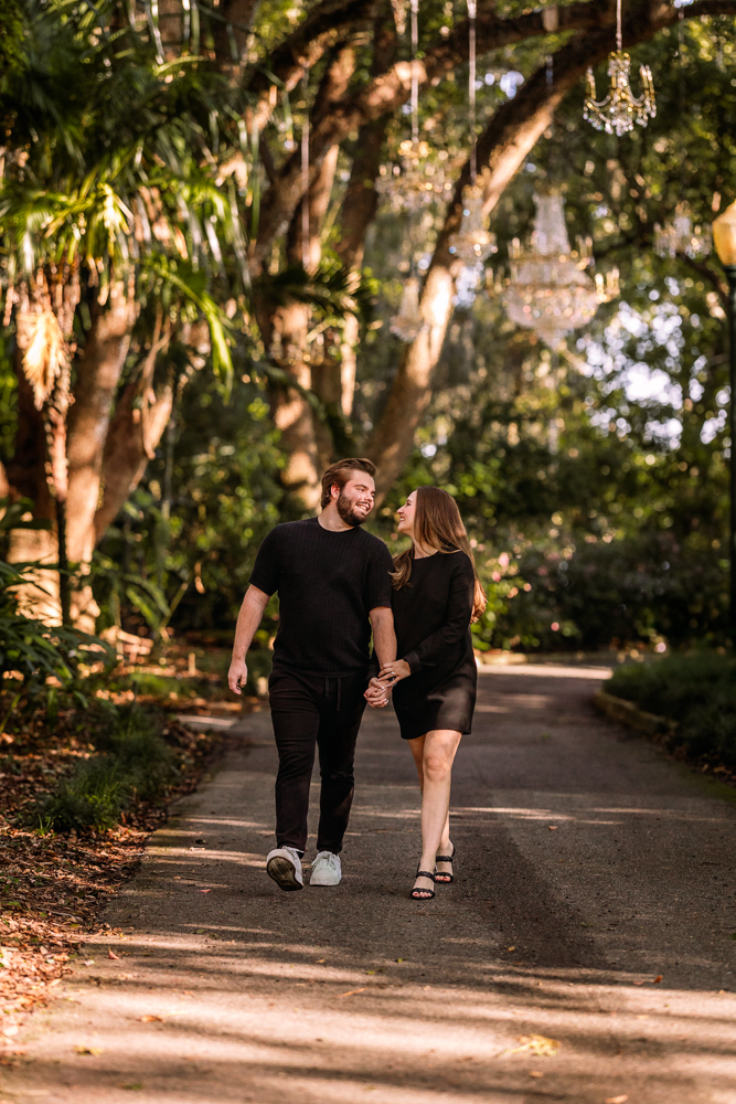 homas and Emily walking hand in hand through the lush gardens at Leu Gardens during their engagement session with Orlando Florida photographer Natalie Szolomayer