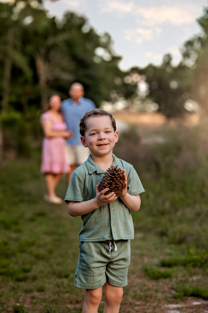 Young Henry Littles playing and smiling during his family photo session at Lake Louisa State Park, Clermont FL