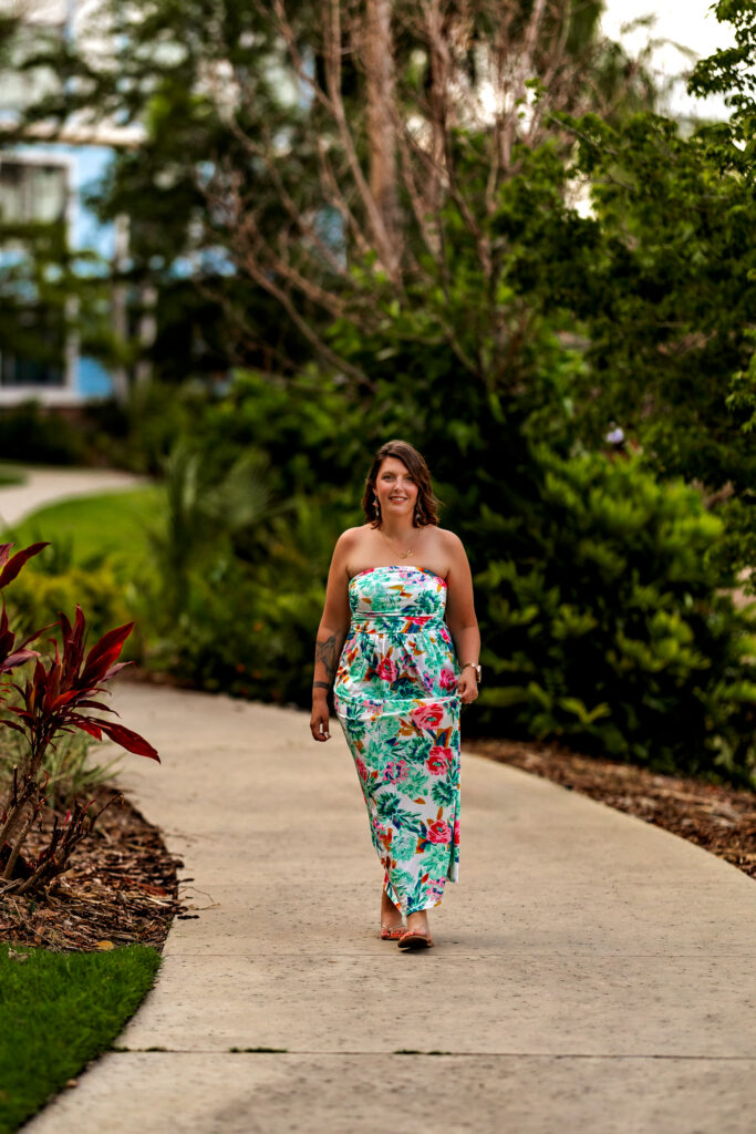 Full body branding shot of Karli at Universal Orlando's Sapphire Falls with palm trees and tropical landscaping