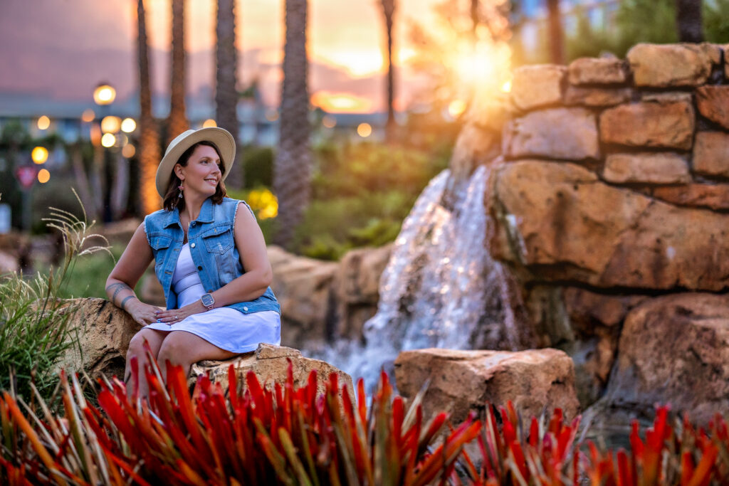 Detail shot of Karli with tropical flowers and resort architecture at Sapphire Falls – high-end branding photography