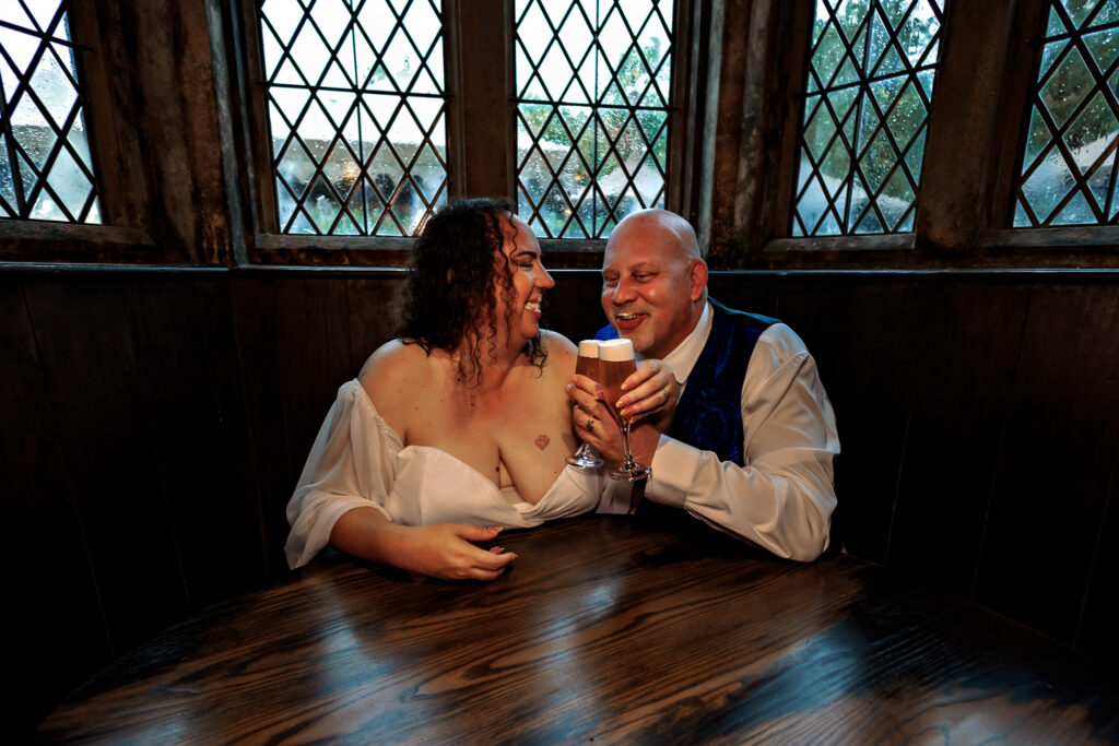 Couple sharing butterbeer by diamond-pane windows in Hogsmeade