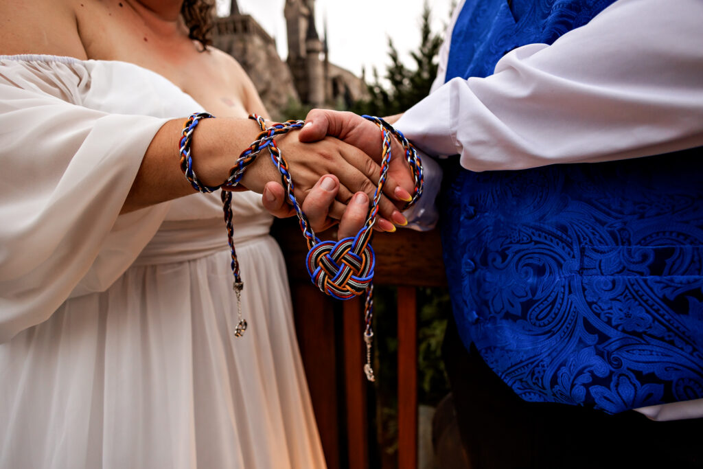 Holding hands on the bridge with Hogwarts Castle in the background